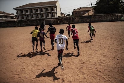 Son las tres de la tarde en el barrio donde antiguamente vivían los colonos portugueses en Bissau. En un terraplén de tierra fina, como la de una playa paradisiaca, pero de color rojizo, un centenar de chavales y niñas entrena su destreza con el balón. Hace mucho calor, pero temperatura infernal y la inestabilidad del terreno no son las únicas adversidades