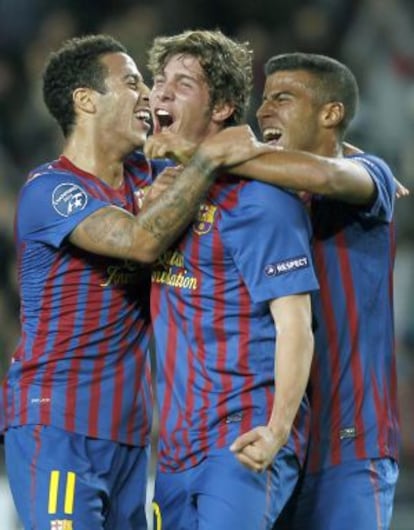 Thiago y Rafinha abrazan a Sergi Roberto, en un partido de 2011.