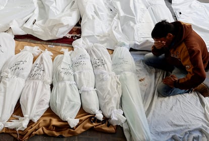 Un hombre llora junto a los cadáveres de varias personas fallecidas tras los bombardeos de Israel sobre el sur de la franja de Gaza.