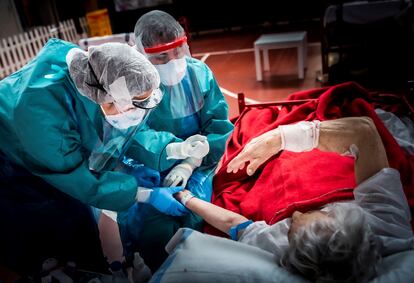 Dos sanitarios del hospital de Aranda de Duero realizan un test a un paciente enfermo de covid-19.