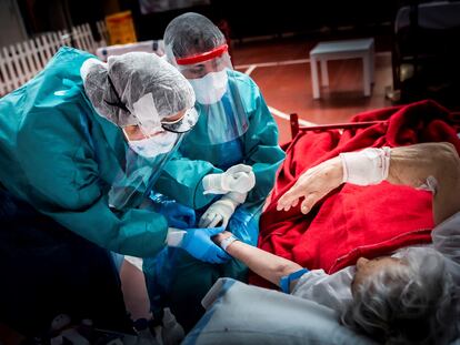 Dos sanitarios del hospital de Aranda de Duero realizan un test a un paciente enfermo de covid-19.