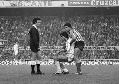 Tello (Betis) levanta Antonio Álvarez ante la presencia de Enríquez Negreira en el Sevilla - Betis (1-1) de la 1981/82.