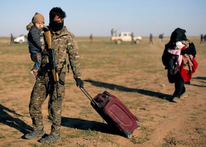 Un combatiente de las Fuerzas Democráticas Sirias (SDF, en sus siglas inglesas), la milicia kurda apoyada por EEUU, ayuda en la evacuación de un bebé de Baghuz, el pasado 1 de marzo.