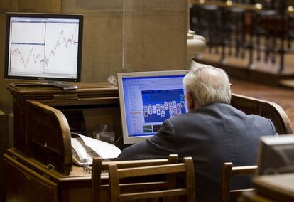 Un broker juega al solitario durante una sesión de la Bolsa de Madrid, el 5 de agosto de 2011. Esta fotografía de Paul White ha obtenido una mención especial del jurado de los premios.