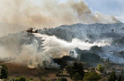 Un hidroavión suelta su carga en el incendio, iniciado a primeras horas de la tarde en un punto limpio de Orense, y que lleva quemadas unas 20 hectáreas.