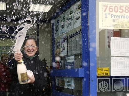 Una mujer descorcha una botella de champ&aacute;n en la administraci&oacute;n n&uacute;mero 12 de Alcal&aacute; de Henares, donde se han vendido 130 series del 76.058