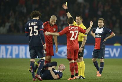 Eren Derdiyok, delantero suizo del Leverkusen recibe una tarjeta amarilla por su entrada al defensa francés Christophe Jallet, del PSG en el partido de vuelta de la Liga de Campeones.