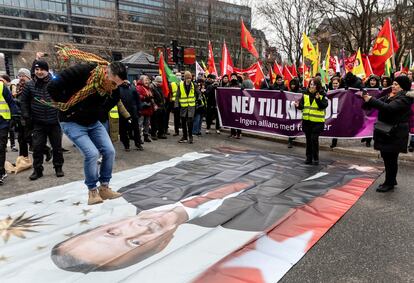 Un manifestante salta sobre una fotografía del presidente turco Erdogan en Estocolmo, este sábado.