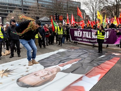 Un manifestante salta sobre una fotografía del presidente turco Erdogan en Estocolmo, este sábado.