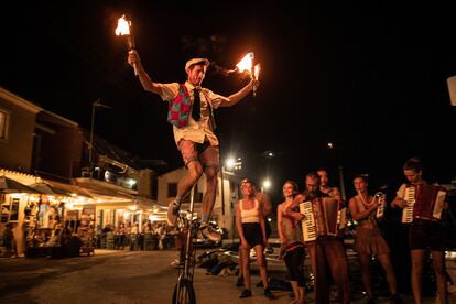 Fred hace malabares con fuego sobre un monociclo en las calles de la isla de Paxos, en agosto de 2021.