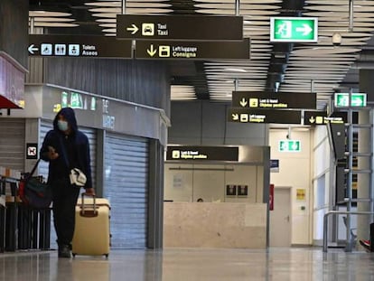 Un viajero transita por el aeropuerto de Madrid-Barajas con tiendas cerradas durante el estado de alarma.