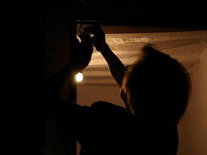 Una mujer revisa la instalación de electricidad de su casa.