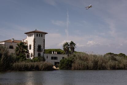 un avión que acaba de despegar del Aeropuerto del Prat sobrevuela la laguna del espacio natural de La Ricarda. / ALBERT GARCIA