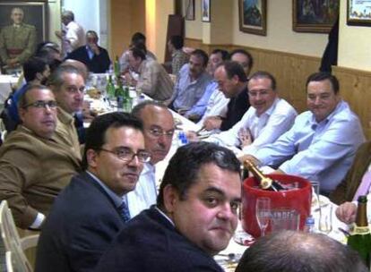 Imagen de la cena en la que cargos de instituciones de Castellón aparecen sentados a una mesa presidida por el retrato de Franco.