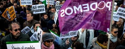Gente portando banderas y carteles en apoyo a Podemos