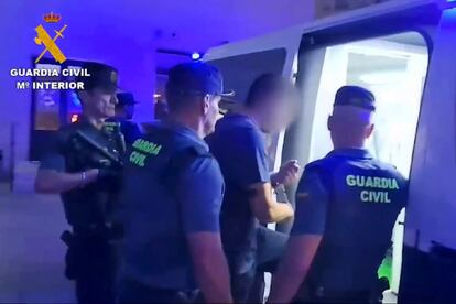 Guardias civiles custodian a Karim El Baqqaly, presunto autor del asesinato de dos guardias civiles, en su traslado este viernes a los juzgados de Barbate (Cádiz), en una imagen del vídeo difundido por el Ministerio del Interior.