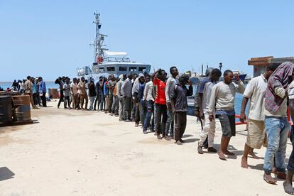 Migrantes rescatados hacen fila en la base naval de Tripolí para ser atendidos.