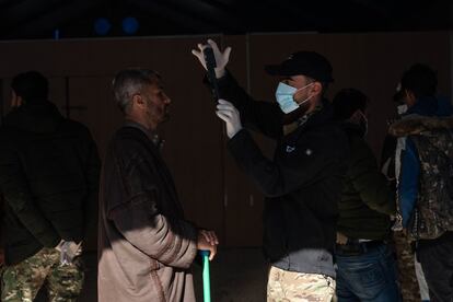 Efectivos de las FDS recogen muestras de ADN, huellas dactilares y datos biométricos de un hombre cautivo en el anexo para iraquíes del campo de Al Hol.