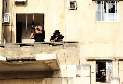 Hombres de seguridad libaneses montan guardia en el balcón del edificio mientras el primer ministro y candidato del Líbano para las próximas elecciones parlamentarias toma parte en una manifestación de campaña en la sureña ciudad portuaria de Sidón.