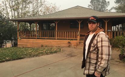 Kevin Guthrie, frente a la casa que logró salvar del fuego, en la que vive con su abuelo.