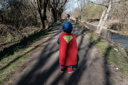 Criança vestida de Super-Homem caminha em em Casalpusterlengo, uma das regiões isoladas na Itália.