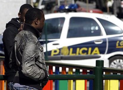 Dos surafricanos, junto a un coche de policía esta mañana en el barrio de Lavapiés.