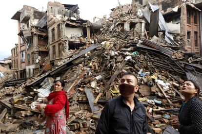 Várias pessoas vasculham os restos de vários edifícios destruídos depois do terremoto no distrito de Bhaktapur (Nepal), 27 de abril de 2015.