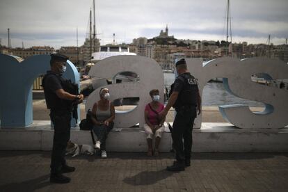 Policías antidisturbios conversan con dos mujeres, en Marsella. Las autoridades sanitarias de Francia han alertado del alto número de casos asintomáticos que hay en el país y han informado de que en el último día se han constatado otros 493 contagios y 19 muertos a causa del coronavirus.