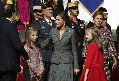 La reina Letizia, junto a la princesa Leonor y la infanta Sofía; y el presidente del Gobierno, Mariano Rajoy (i), y la ministra de Defensa, María Dolores de Cospedal (d).