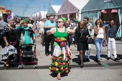 Una senyora balla a la fira vestida de flamenca. 