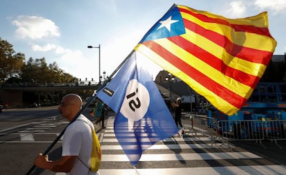 Un hombre porta una estelada por la calle.