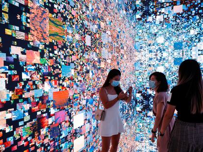 Tres visitantes a la Feria de Arte Digital de Hong Kong junto a una obra inmersiva de Refik Anadol que se convertirá en un certificado digital único (NFT) y se subastará en Sotheby's.