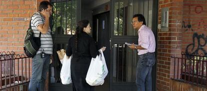 Unos periodistas hablan con una vecina en el portal donde se ha producido la agresión.