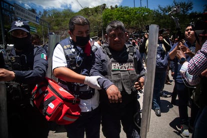 Uno de los policías retenidos es apoyado por un paramédico tras ser liberado por los manifestantes, el 11 de julio en Chilpancingo (Guerrero).