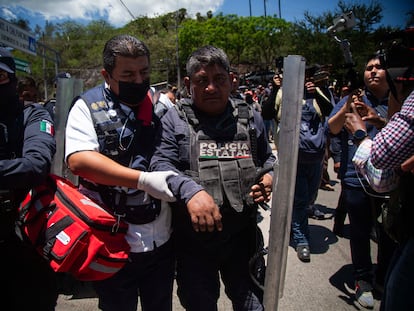 Uno de los policías retenidos es apoyado por un paramédico tras ser liberado por los manifestantes, el 11 de julio en Chilpancingo (Guerrero).