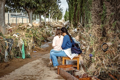 Una mujer y su hija descansan entre juncos en el barranco del Poyo que quedó arrasado tras el paso de la dana, el 30 de octubre. 