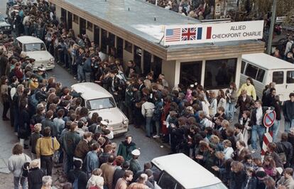 Cidadãos da Alemanha Ocidental aplaudem os orientais que cruzam o posto fronteiriço conhecido como Checkpoint Charlie.