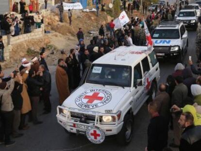 Un grupo de sirios tras cruzar el paso fronterizo liban&eacute;s de Masnaa este lunes en un convoy de la Cruz Roja y la ONU.