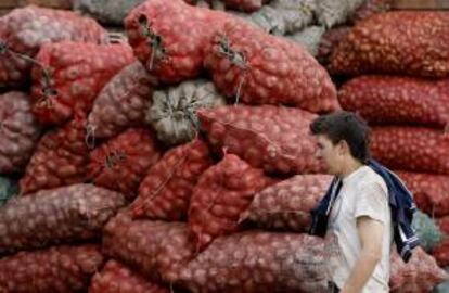 Un trabajador camina frente a sacos con alimentos  en la Central de Abastos en Bogotá. Carreteras de nueve departamentos se mantienen bloqueadas, lo que ha reducido el traslado de productos a los mercados nacionales en el sexto día de huelga del sector agropecuario.