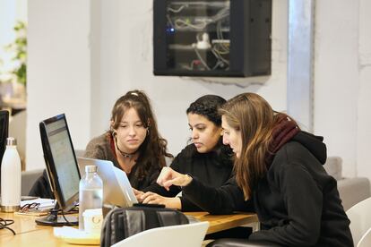 Tres estudiantes de Programación trabajan junto a un ordenador en la sede de Barcelona.