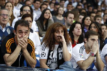 Los aficionados del Real Madrid muestran su decepci&oacute;n al ver el gol de Godin para el Atl&eacute;tico. 