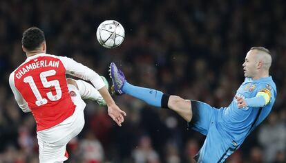 Andrés Iniesta intenta golpear el balón frente al jugador del Arsenal Alex Oxlader.