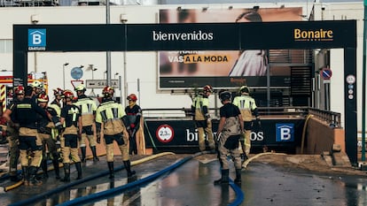 Un grupo de bomberos a la entrada del parking del centro comercial Bonaire, en Valencia, tras la dana. 