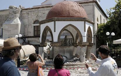 Turistas ao lado de uma construção atingida pelo terremoto em Kos