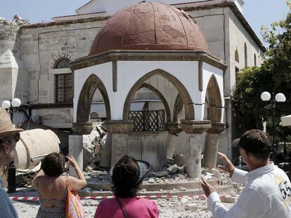 Turistas ao lado de uma construção atingida pelo terremoto em Kos