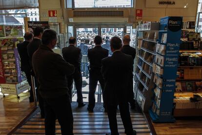 'Piquetes y guardianes', finalista. Varios miembros del personal de seguridad de un establecimiento comercial observan a los piquetes y manifestantes durante una huelga general del 29 de marzo de 2012.