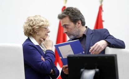 La alcaldesa Manuela Carmena charla con el concejal Mauricio Valiente durante un pleno del Ayuntamiento de Madrid.