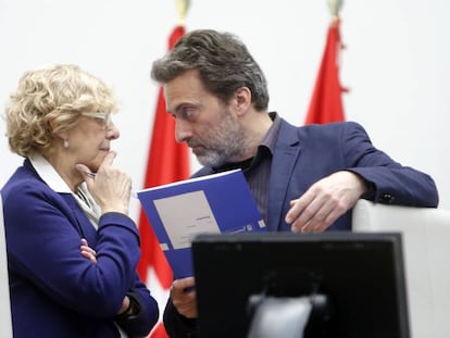 La alcaldesa Manuela Carmena charla con el concejal Mauricio Valiente durante un pleno del Ayuntamiento de Madrid.