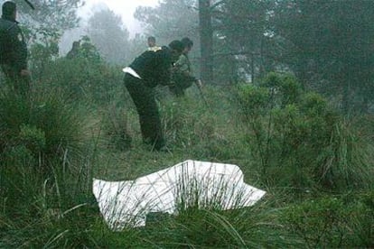 Los equipos de rescate trabajan junto a uno de los cadáveres recuperados en la zona del siniestro del helicóptero.