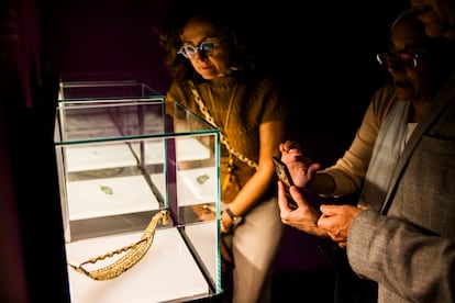 Dos visitantes de la muestra observan una fbula con forma de dragn.